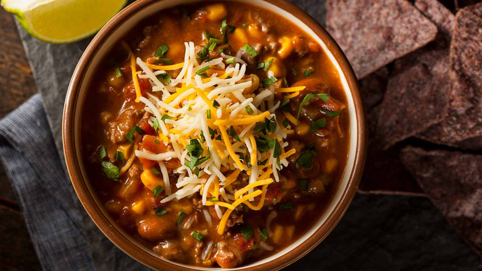 A bowl of chili topped with shredded cheese